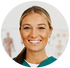 Smiling female healthcare professional chiropractor with blonde hair in a ponytail, wearing a teal uniform in a circular frame